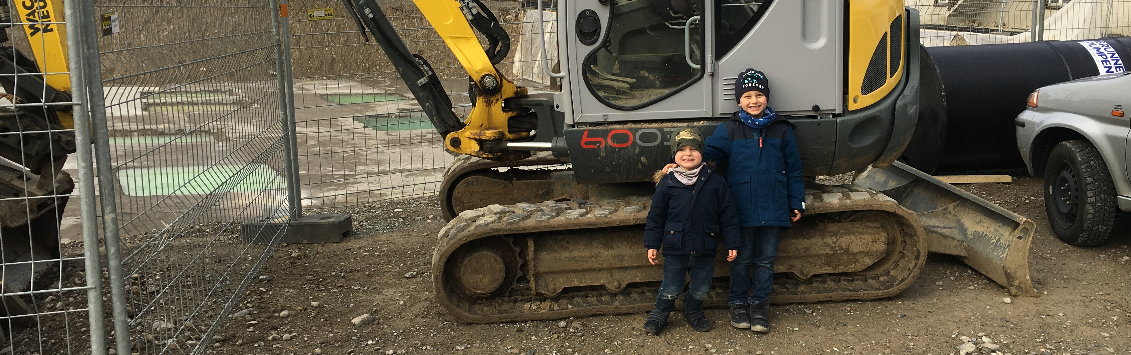zwei Jung vor einem Bagger